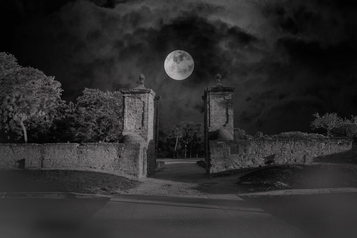 A full moon sits behind the city gate of St. Augustine, Florida.